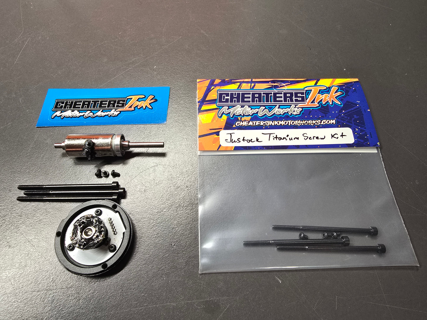 The image shows a Hobbywing Justock Black Titanium Screw Kit, including sensor board and stator screws, packaged in a clear plastic bag with a blue and orange label.